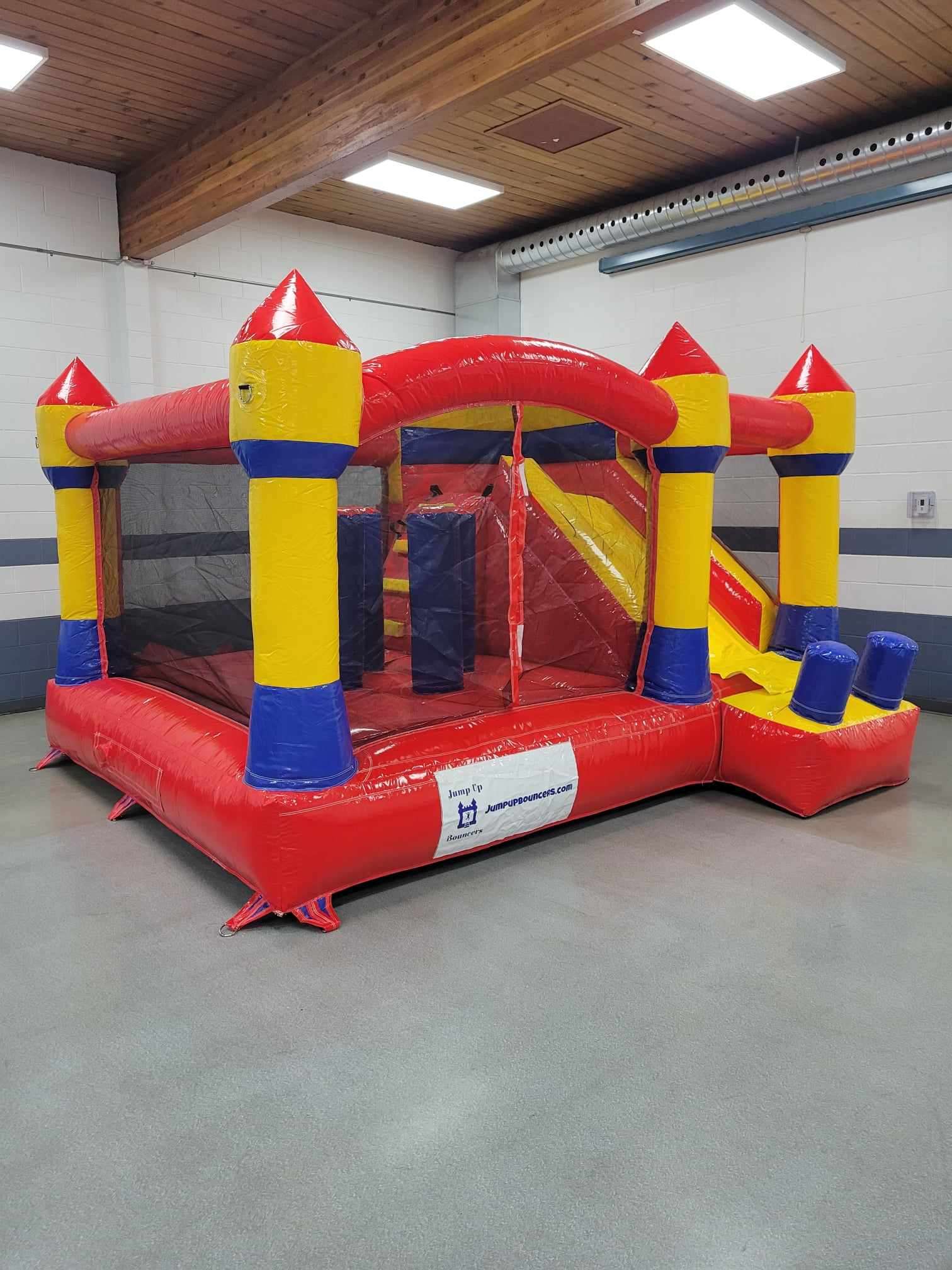 Indoor friendly yellow and red jump and slide bouncy castle rental in Manitoba